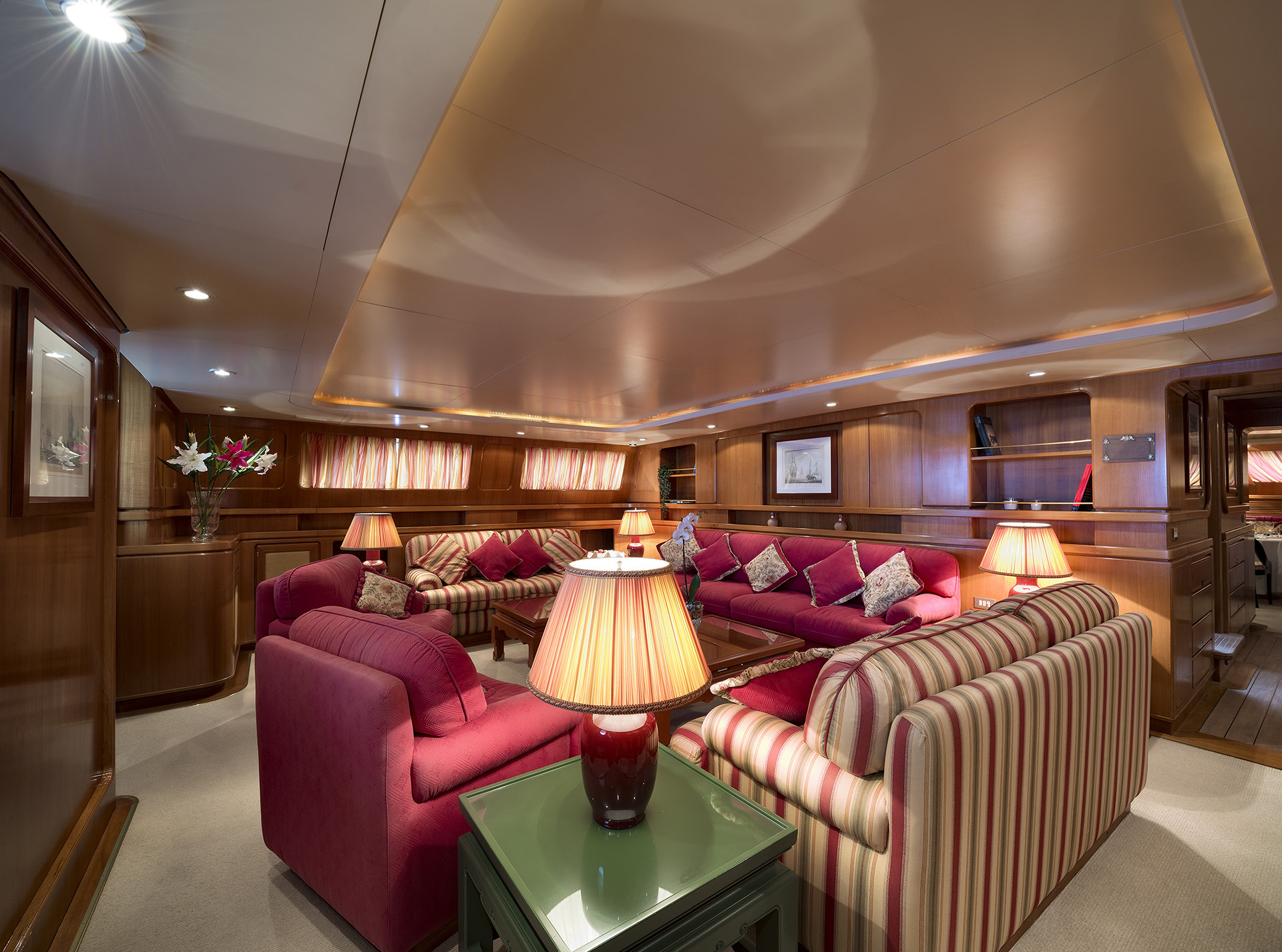 Yacht saloon with red sofas and timber panelling