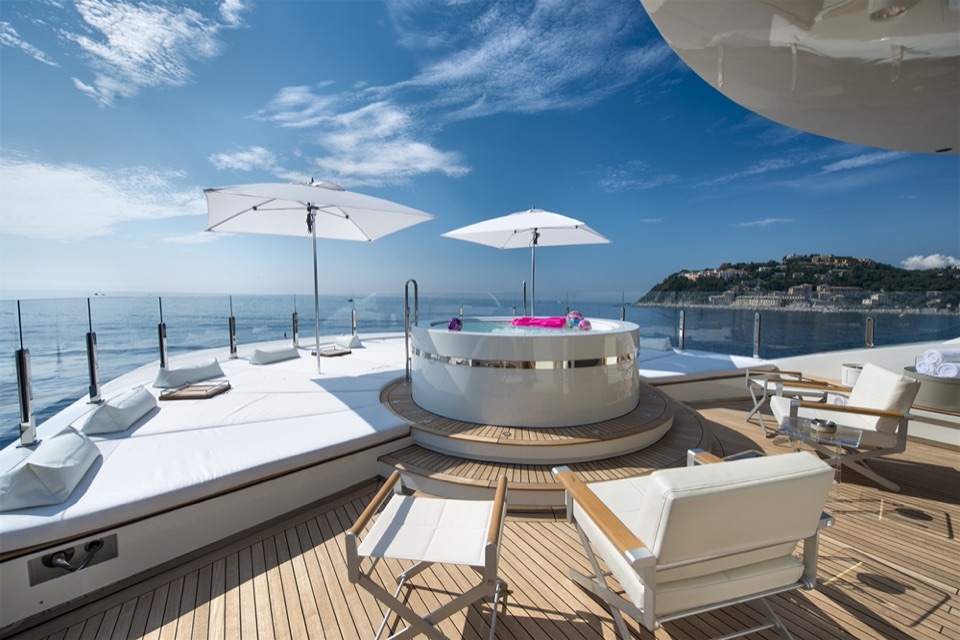 Sun deck with spa pool and parasols, the headland behind