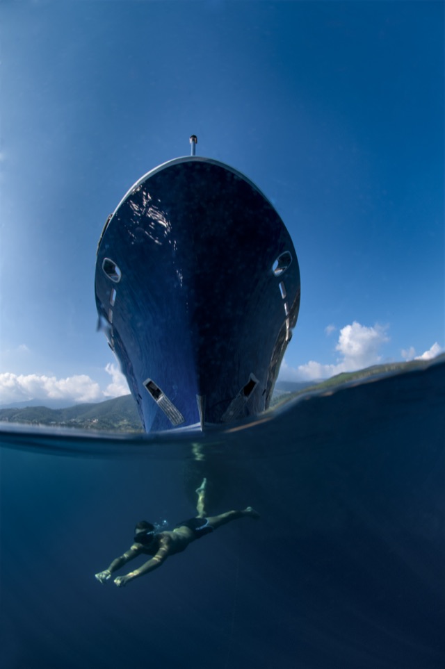 Bow of M/Y My Dream seen head-on from the water line, swimmer underwater